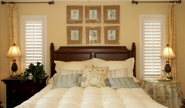 Beige bedroom with white plantation shutters covering windows in Kingsport 
